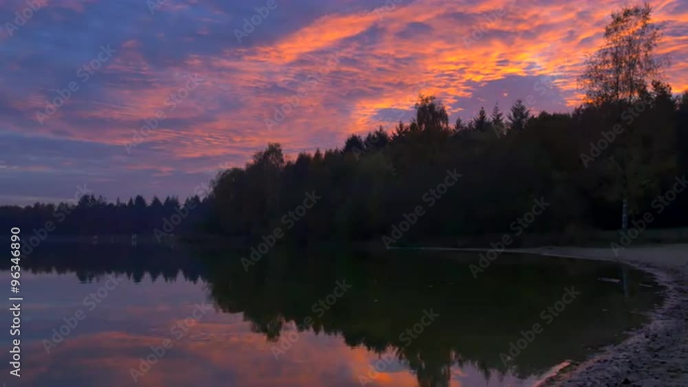 Colorful sunset over a calm lake in nature at the end of an autumn day. Colorful sunset over a calm lake in nature at the end of an autumn day.