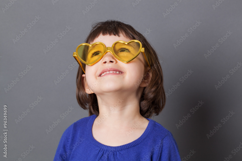 fun kid glasses concept - smiling preschool child wearing yellow heart-shape glasses for comic disco outfit or positive future,studio shot fun kid glasses concept - smiling preschool child wearing yellow heart-shape glasses for comic disco outfit or positive future,studio shot