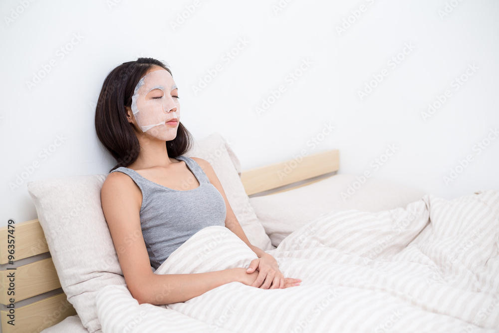 Young woman use of the paper mask in bed Young woman use of the paper mask in bed