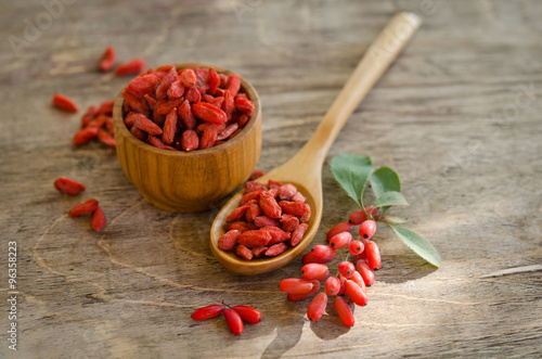 barberries and goji berries on wooden background