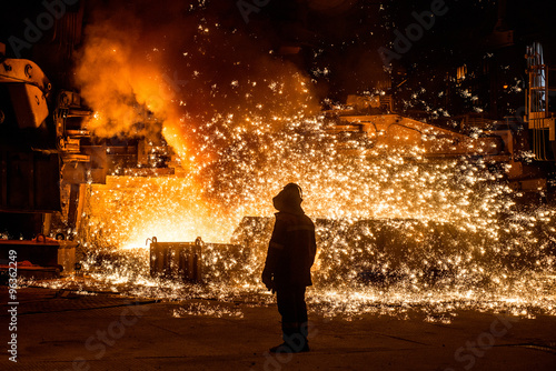 Fototapeta Naklejka Na Ścianę i Meble -  Steelworker near a blast furnace with sparks