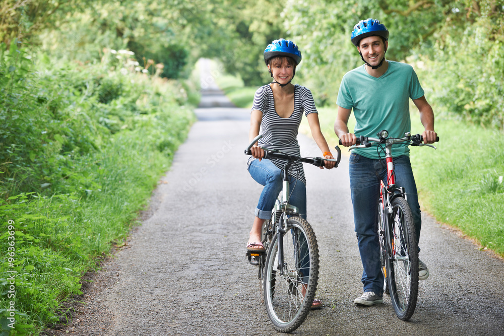 Young Couple Cycling Along Country Road