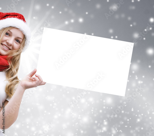 Mädchen mit Weihnachtsmütze und Grußkarte