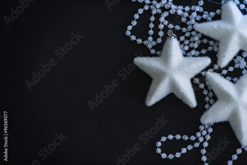 Three white stars and crystalline beads on the painted black background.