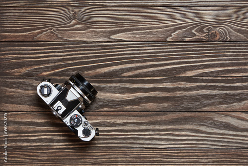 Retro SLR camera on old wooden background