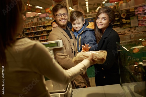 Family buying bread in a grocery store
