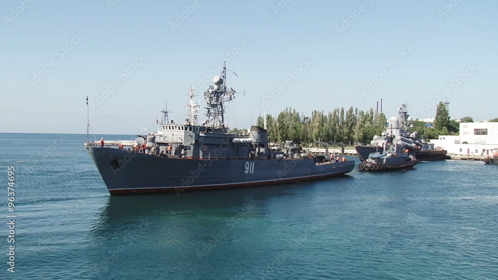warship with the help of tugboats moored warship with the help of tugboats moored