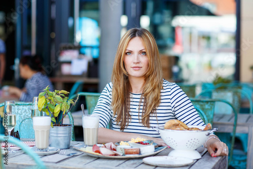 Young woman having healthy breakfast in outdoor cafe © Irina Schmidt
