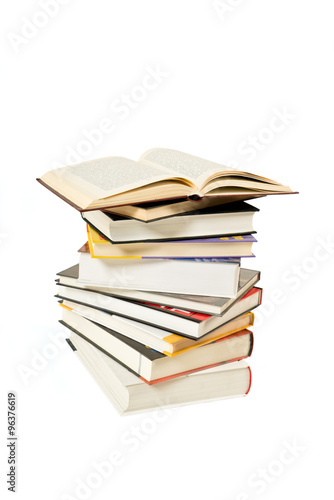 Stack of books and one open book on white background
