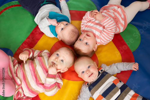 Overhead View Of Babies Lying On Mat At Playgroup