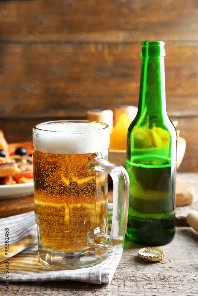 Sliced pizza served with beer on wooden table Sliced pizza served with beer on wooden table