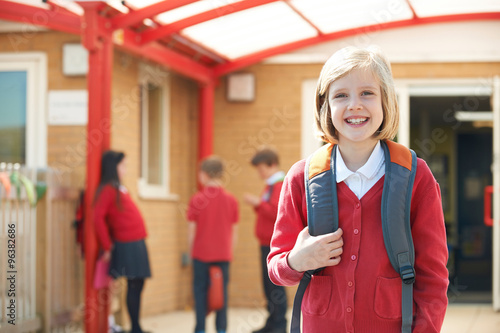 Girl Wearing Uniform Standing In School Playground