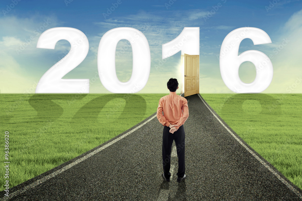 Male worker looking at numbers 2016 on the road Male worker looking at numbers 2016 on the road