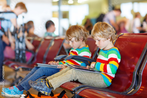 Two tired little sibling boys at the airport