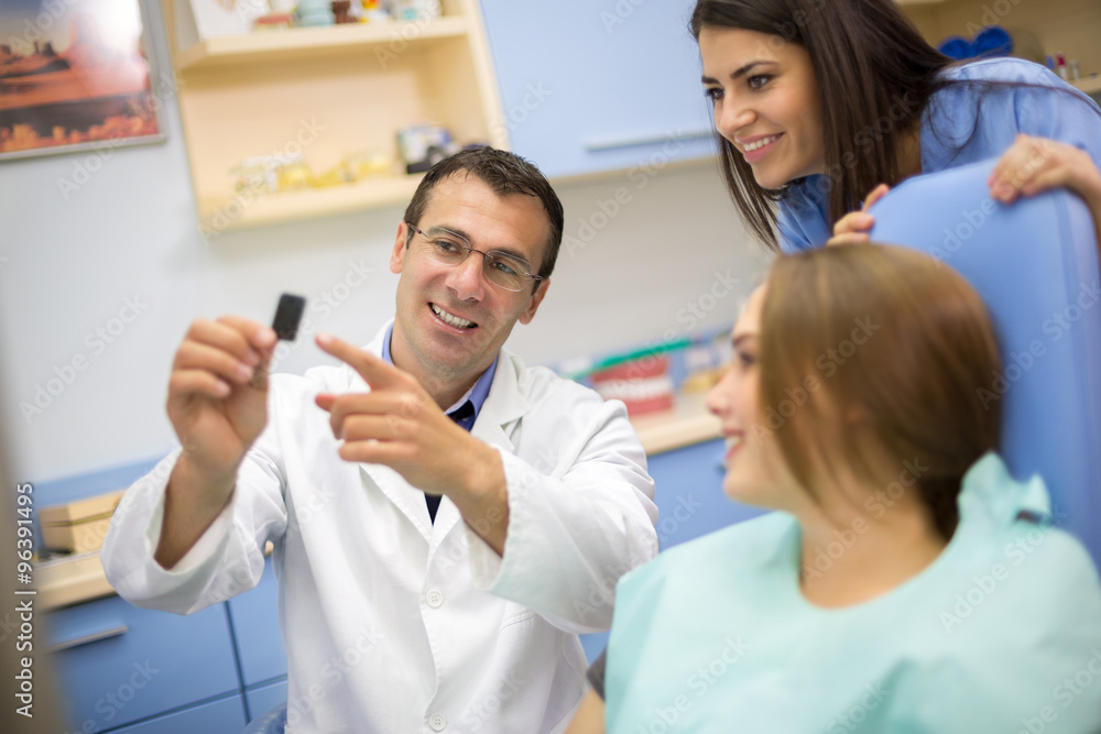 Dentist show dental film to patient and dental technician Dentist show dental film to patient and dental technician