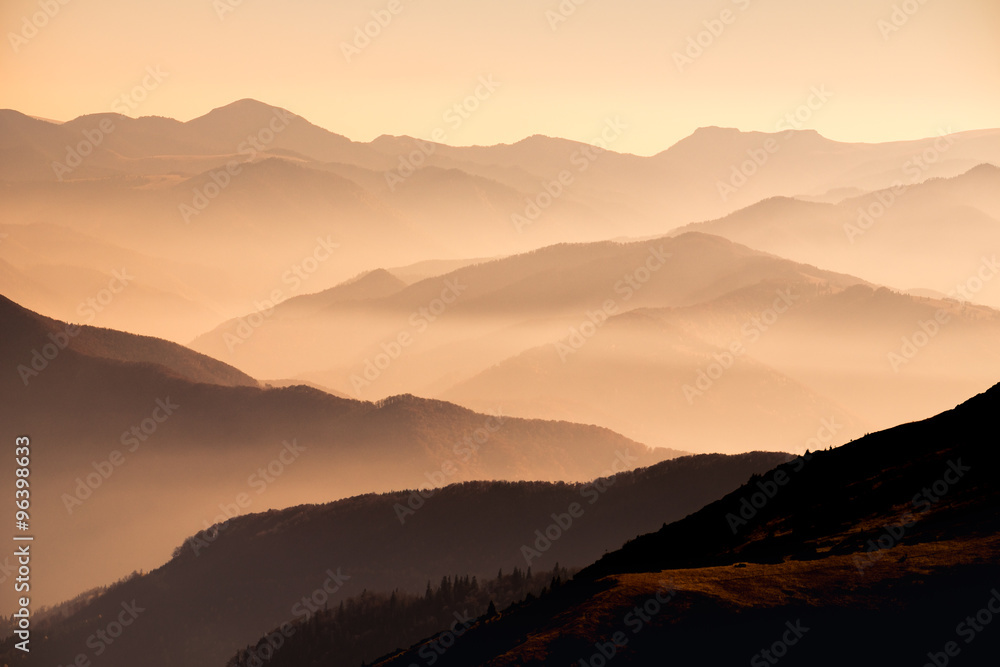 Landscape view of misty mountain hills at sunset