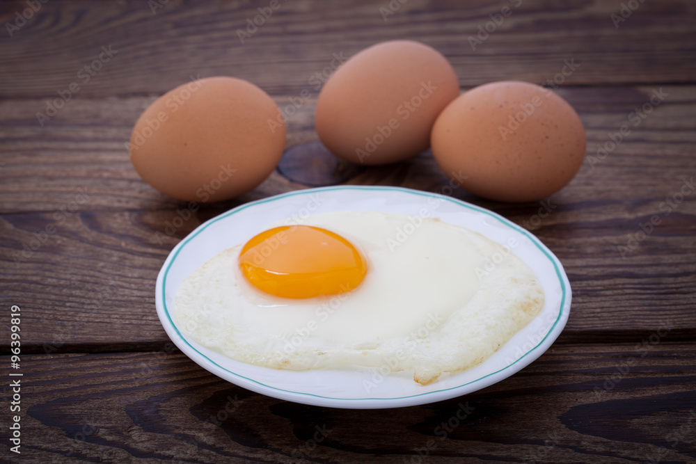 Fried eggs breakfast bachelor on wooden table Fried eggs breakfast bachelor on wooden table
