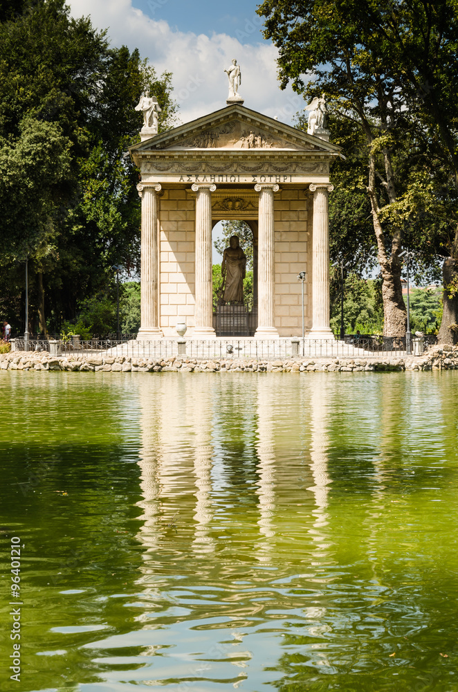 small temple in roman style on the shore of artificial lake on villa borgese garden