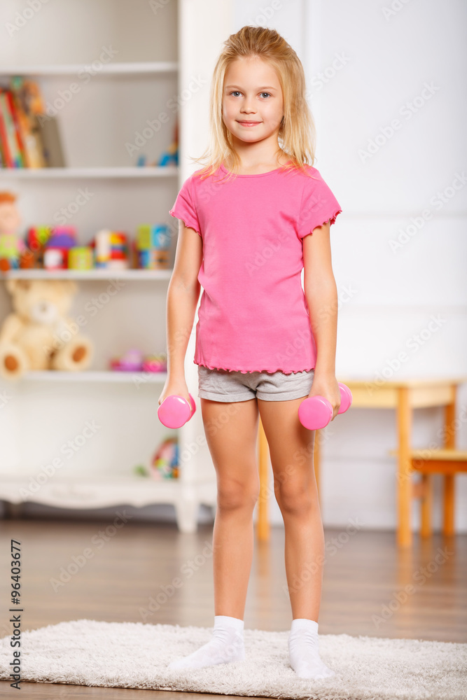Little girl holding dumbbells. Little girl holding dumbbells.