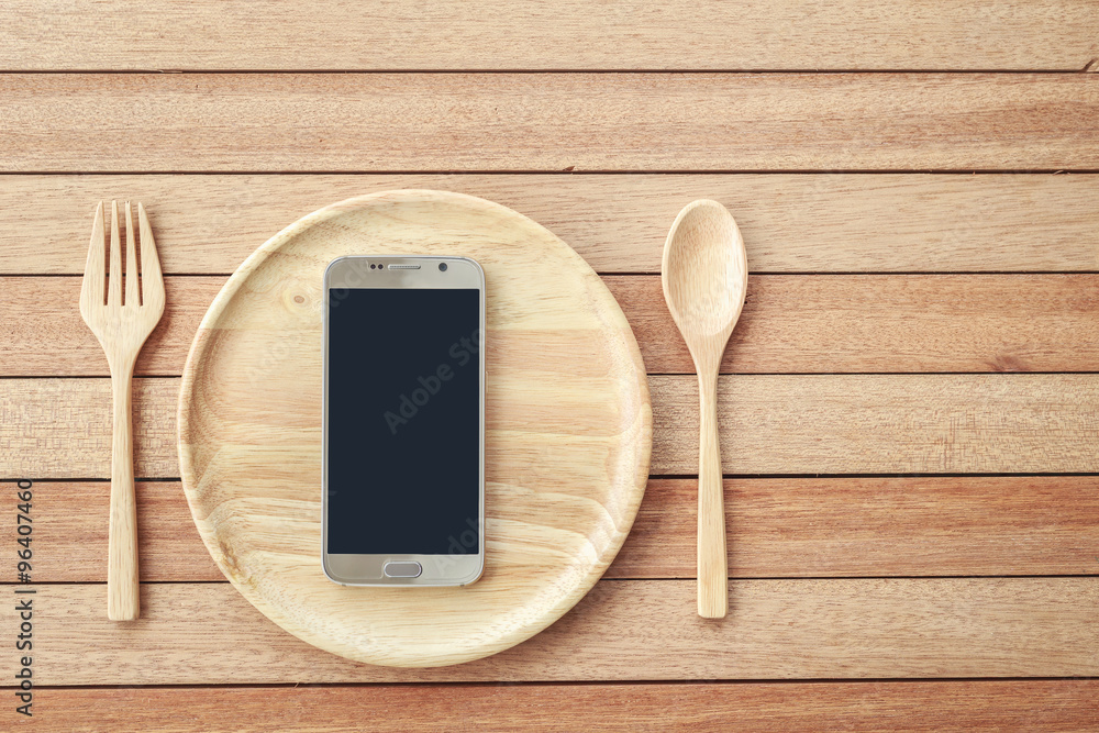Top view smartphone on wooden dish on wooden plank background