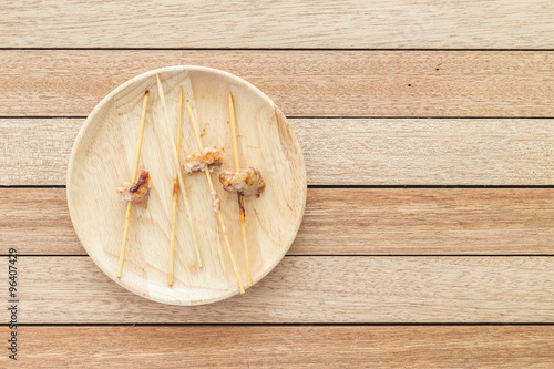 Empy bamboo stick of grilled pork on wooden dish