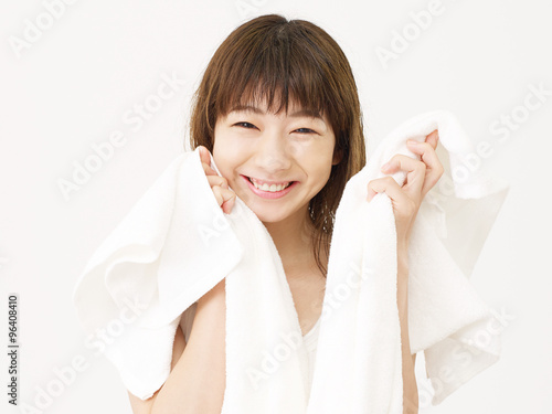 お風呂上がりに顔を拭く女性