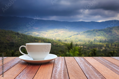 White coffee cup on wood table and view of nature background