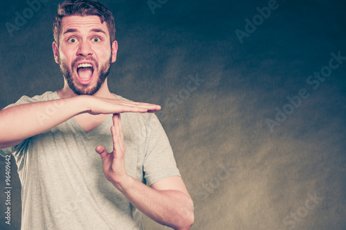 Man showing time out gesture sign and screaming.