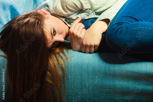 Sad woman laying on couch