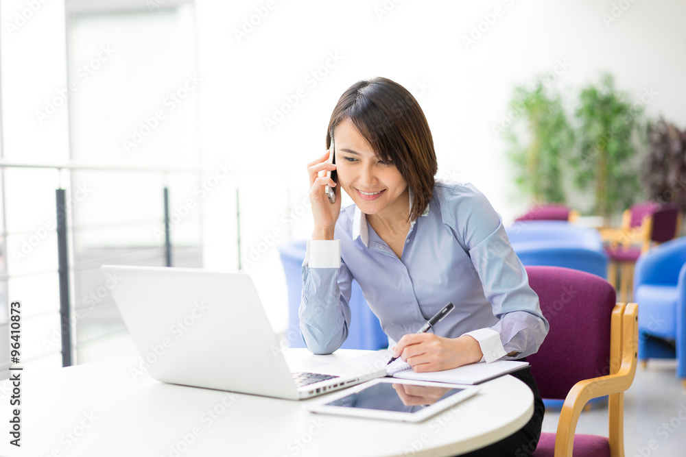 Asian Businesswoman sitting at her desk in an office Asian Businesswoman sitting at her desk in an office