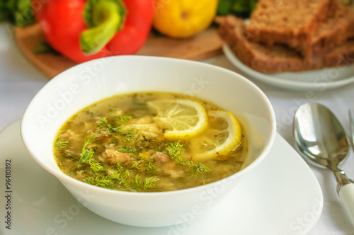 Homemade fish soup with tuna and rice served with dark bread and dill