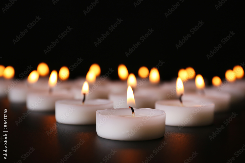 Alight candles in a row on black background Alight candles in a row on black background