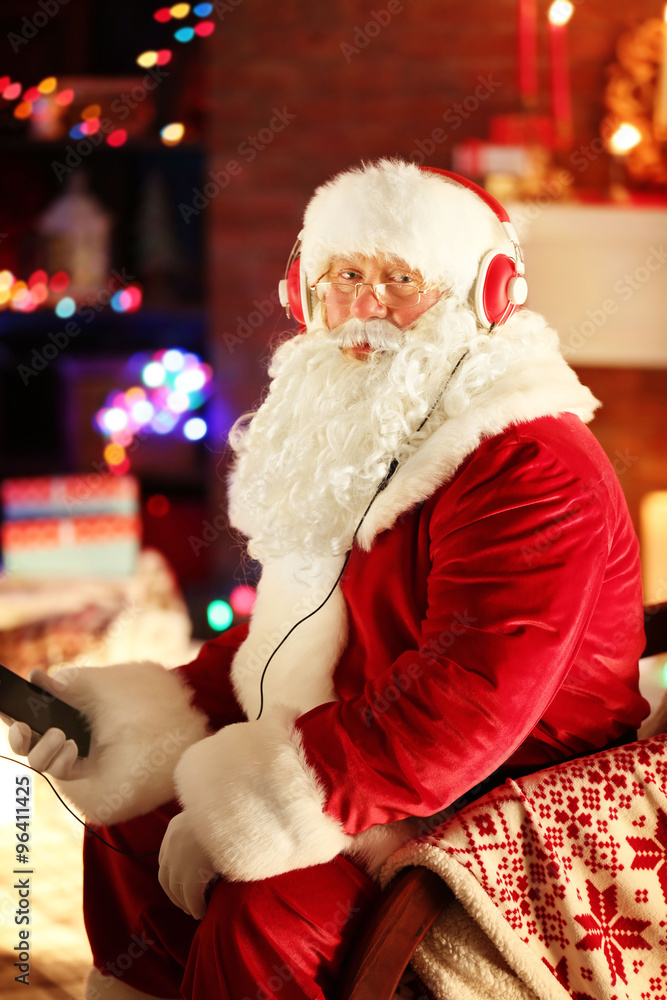 Santa Claus sitting with headphones sitting in comfortable rocking chair at home Santa Claus sitting with headphones sitting in comfortable rocking chair at home