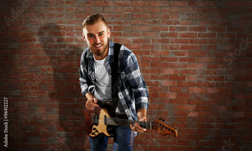 Wallpaper Mural Young man playing guitar on brick wall background Torontodigital.ca