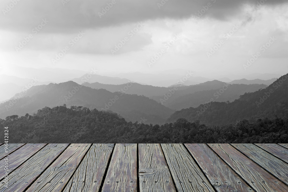 wooden floor with misty mountain hills landscape background