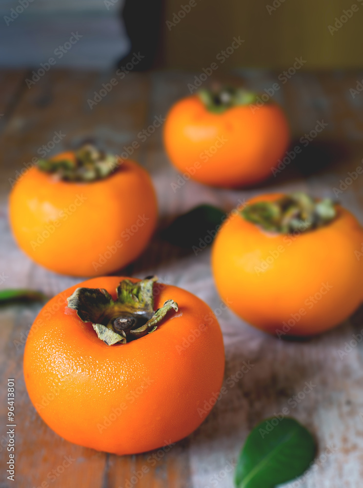 persimmon on rustic wooden background persimmon on rustic wooden background