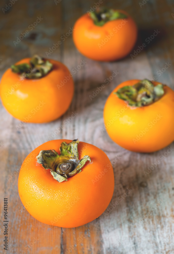 persimmon on rustic wooden background persimmon on rustic wooden background