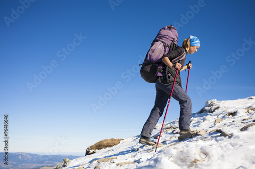 The girl with the backpack is on the slope.