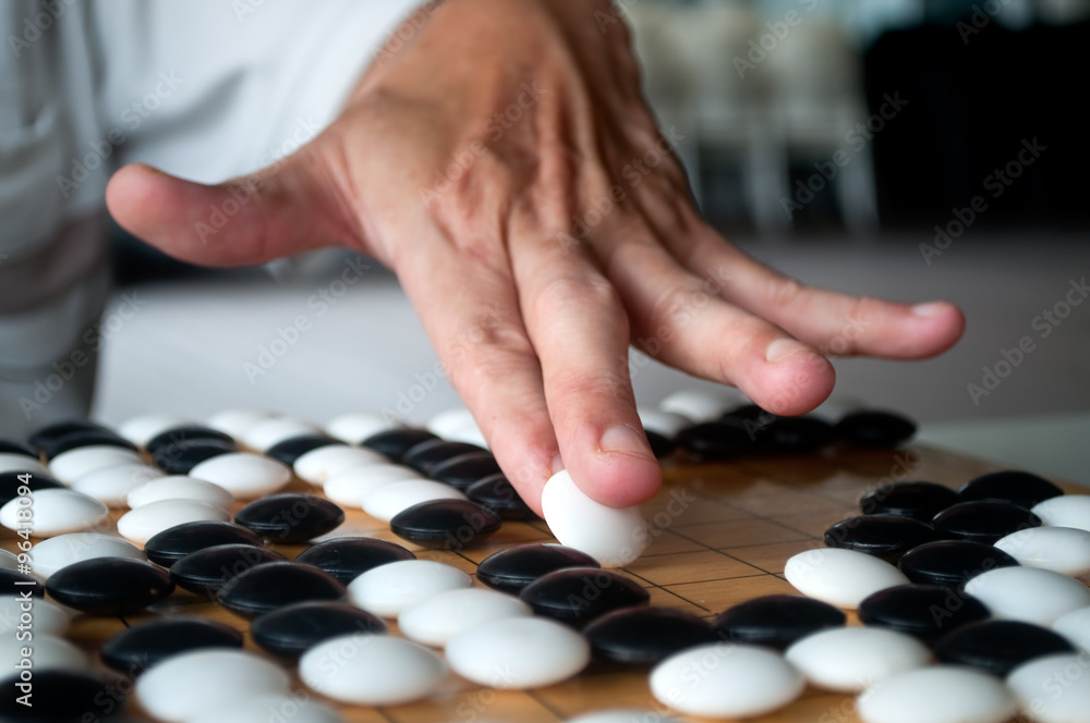 White Go player making his move White Go player making his move