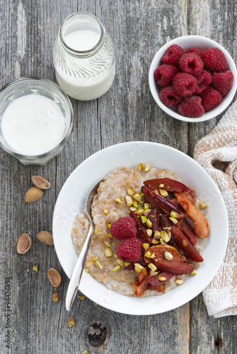 oatmeal with baked fruit and pistachios for breakfast, vertical