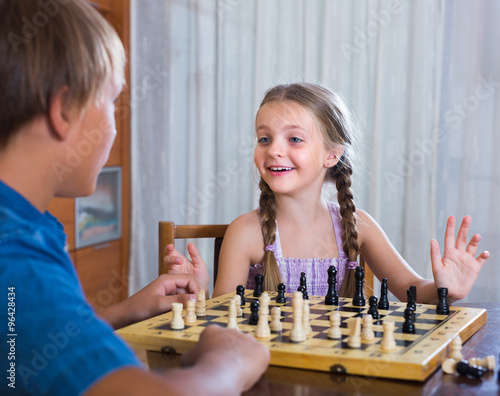 Children playing chess at home.