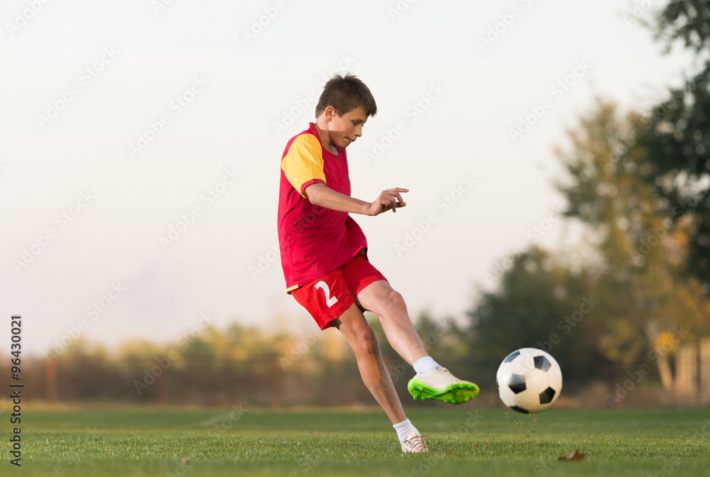 kid kicking a soccer ball
