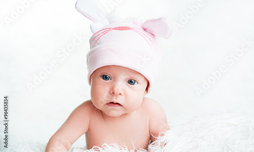 Cute newborn baby girl in a pink hat with ears