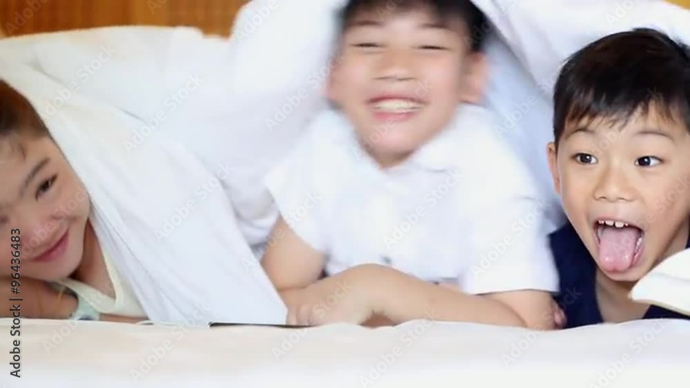 Happy Asian family are playing hide and seek , laying on bed. Happy Asian family are playing hide and seek , laying on bed.