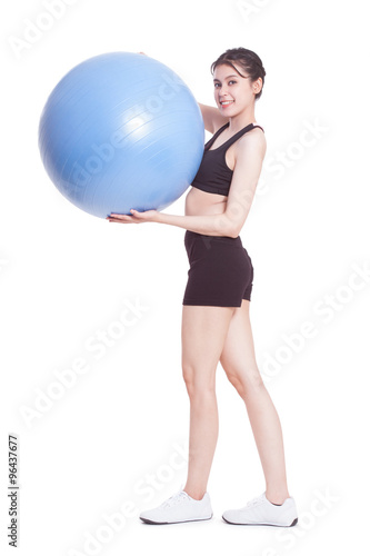 Full length young woman doing exercises with fitness ball.