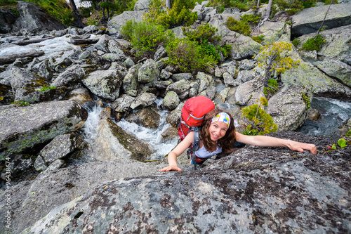 Young woman is climbing at stone whike trekking in highlands of photo