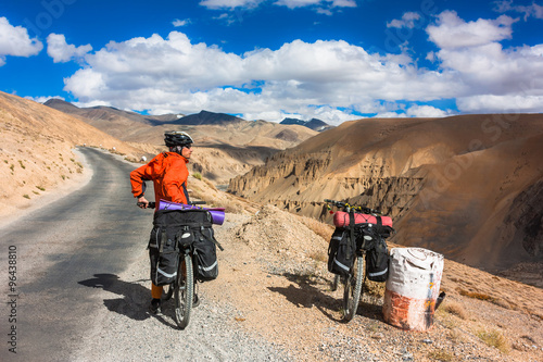 Cyclist standing on mountains road. Himalayas, Jammu and Kashmir State, North India