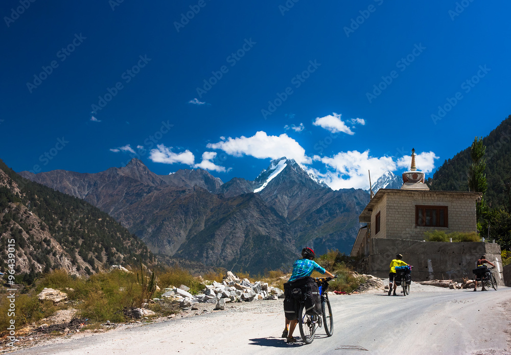 Young bicyclist standing on mountain road, Jammu and Kashmir State, North India