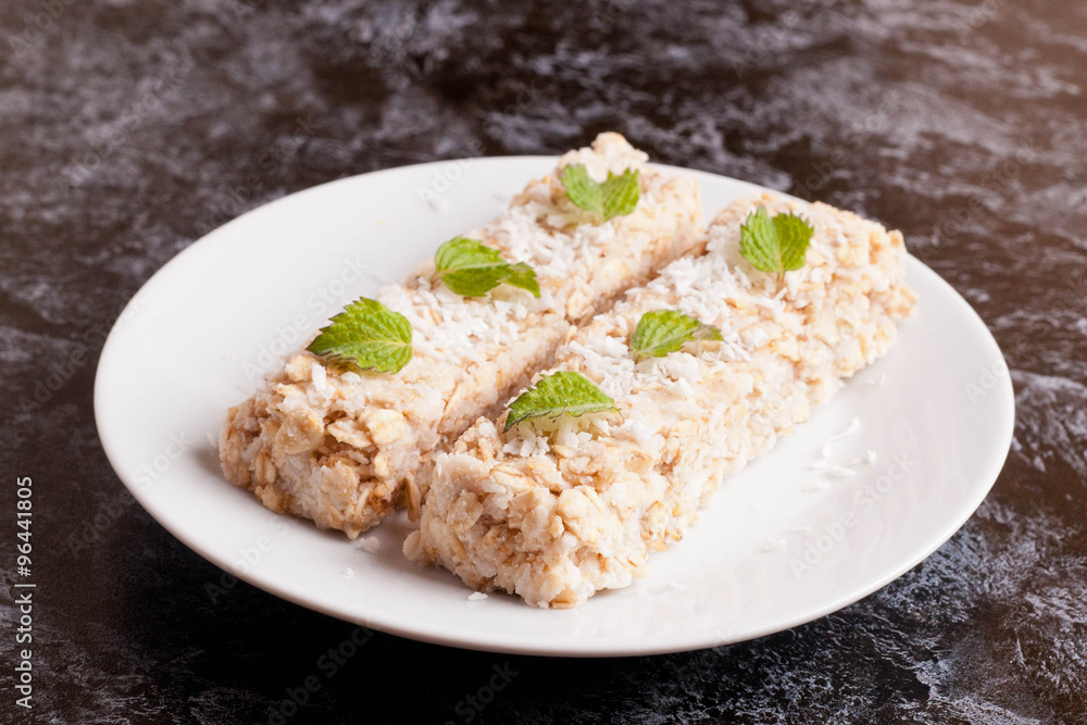 oat bar with coconut with mint on a plate, close up oat bar with coconut with mint on a plate, close up