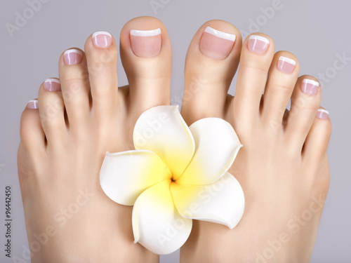 female feet with white french pedicure on nails. at spa salon